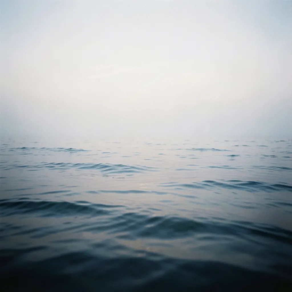 Finding Stillness Under the Pisces Moon and Saturn Transits Soft misty morning over calm water under a pale moody sky, gentle waves — Finding Stillness Amidst the Pisces Moon